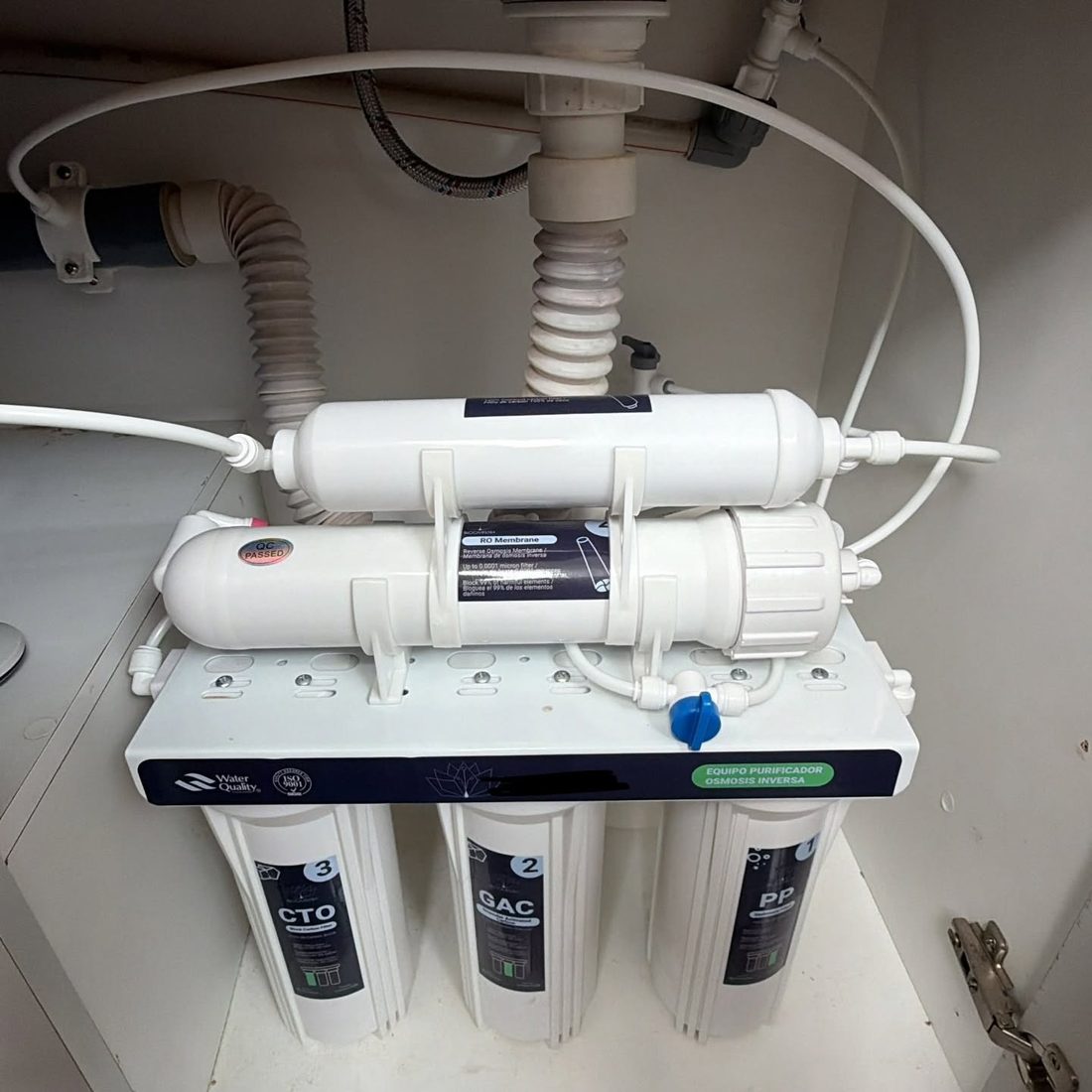 Equipo de osmosis inversa instalado bajo un lavaplatos, con sus tres prefiltros, la membrana y el postfiltro